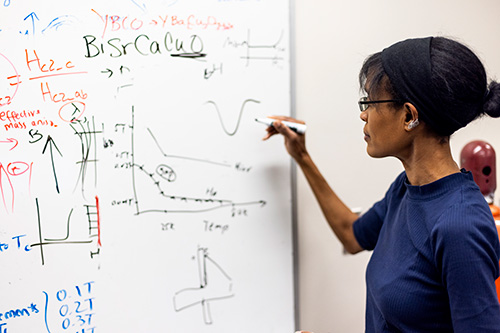 A researcher writes on a white board